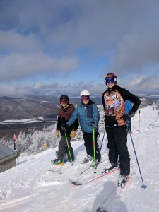 Three students posing while skiing.