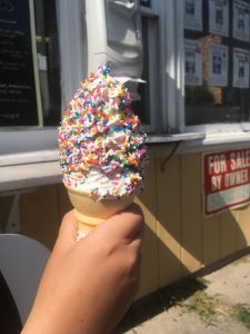 A vanilla ice cream cone with rainbow sprinkles.