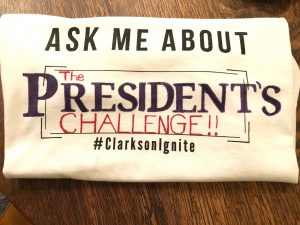 a t-shirt reading 'Ask me about The President's Challenge'