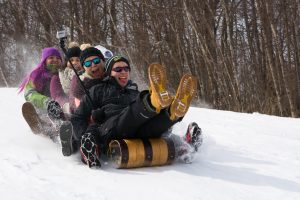 Students sledding in a toboggan down a snowy hill at Clarkson University