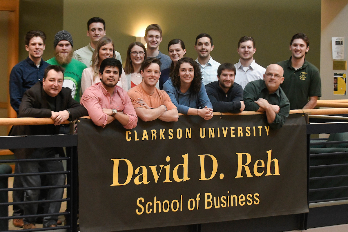 Reh School of Business MBA students standing in front of a Reh School of Business sign