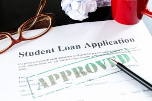 A paper with the words Student Loan Application and a green stamp that reads approved