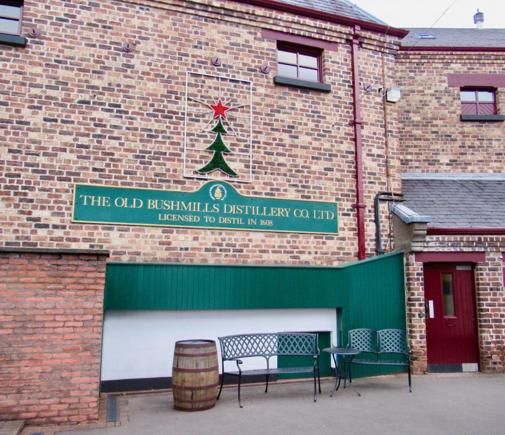 An old brick building. With a sign that reads The Old Bush-mills Distillery co. ltd