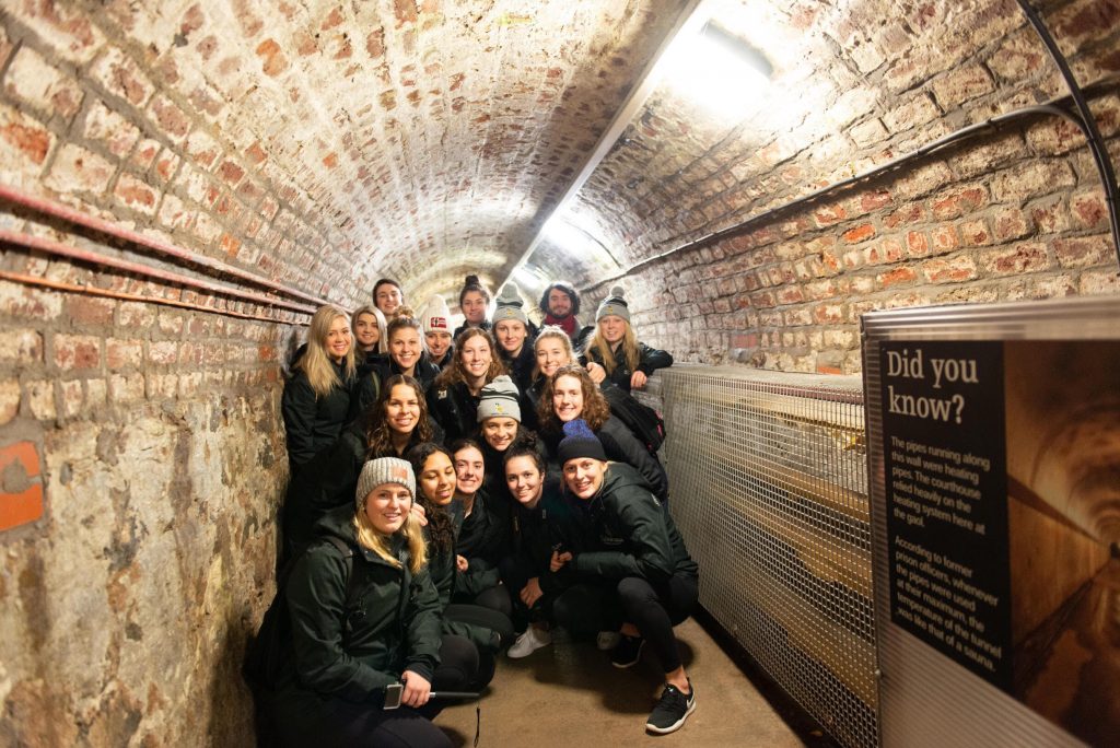 A group of women in a tunnel that is brick