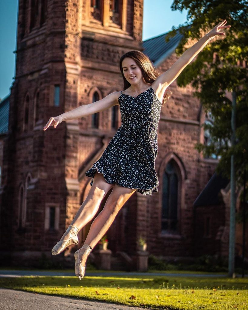 A model wearing ballet point shoes dances in front of Trinity Church as she has her photo taken by Clarkson student Jada Flanagan in downtown Potsdam, New York. 