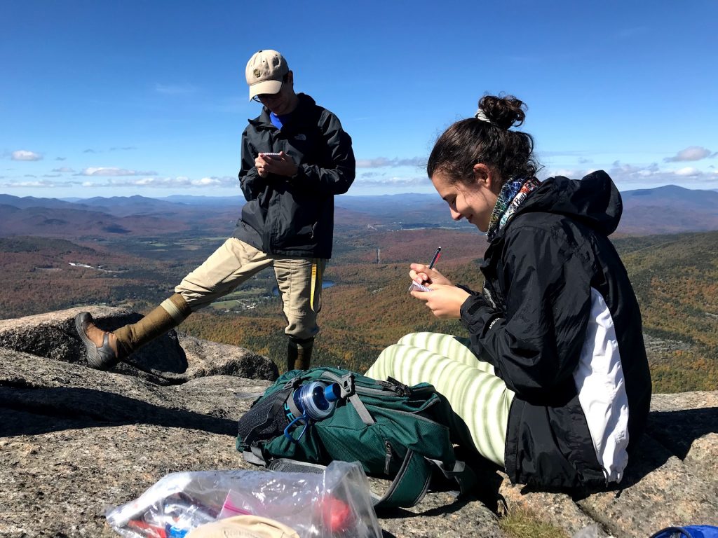 Students doing hand-on environmental field work at the top of a mountain.