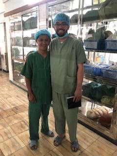 Two people standing in full medical scrubs
