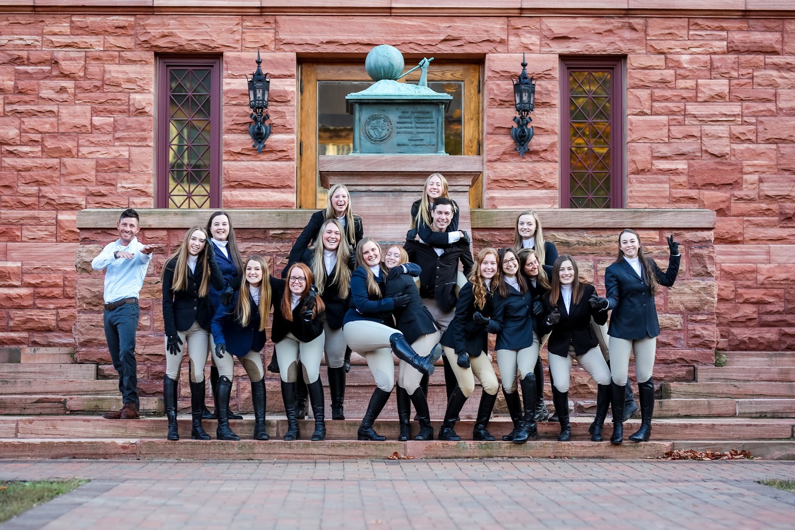 Clarkson University Equestrian team posing in front of Clarkson's Old Main steps