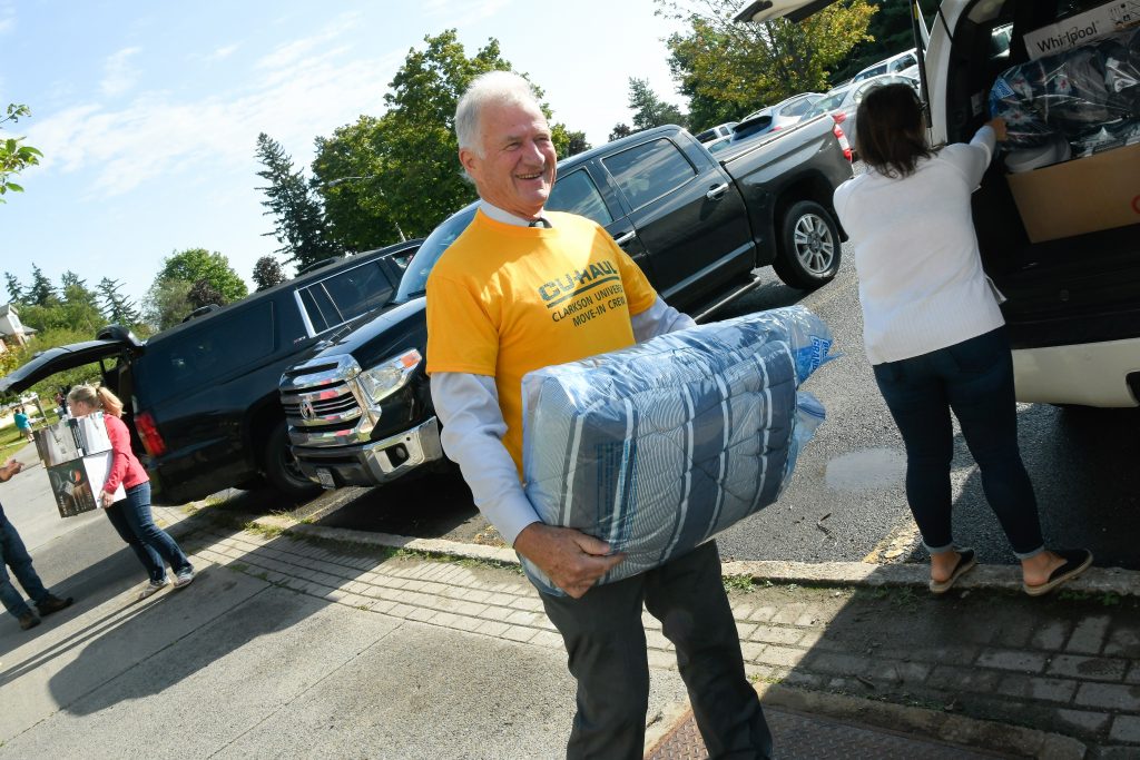 President Tony Collins holding a pillow while walking 