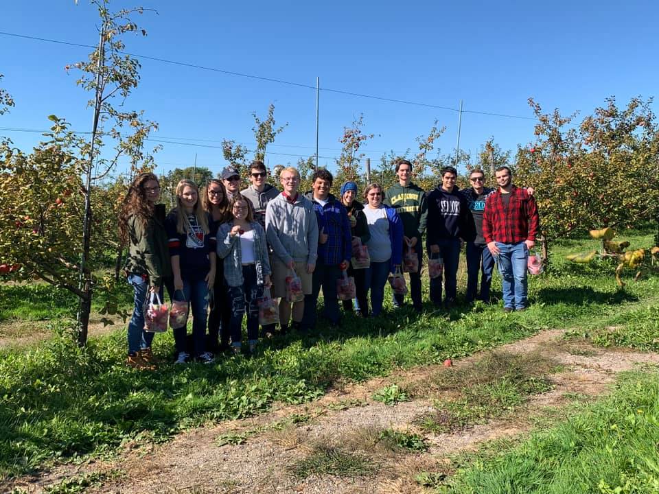 Clarkson student Nick Schalago poses with a large group of fellow Pep Band students during an outing to an apple orchard. 