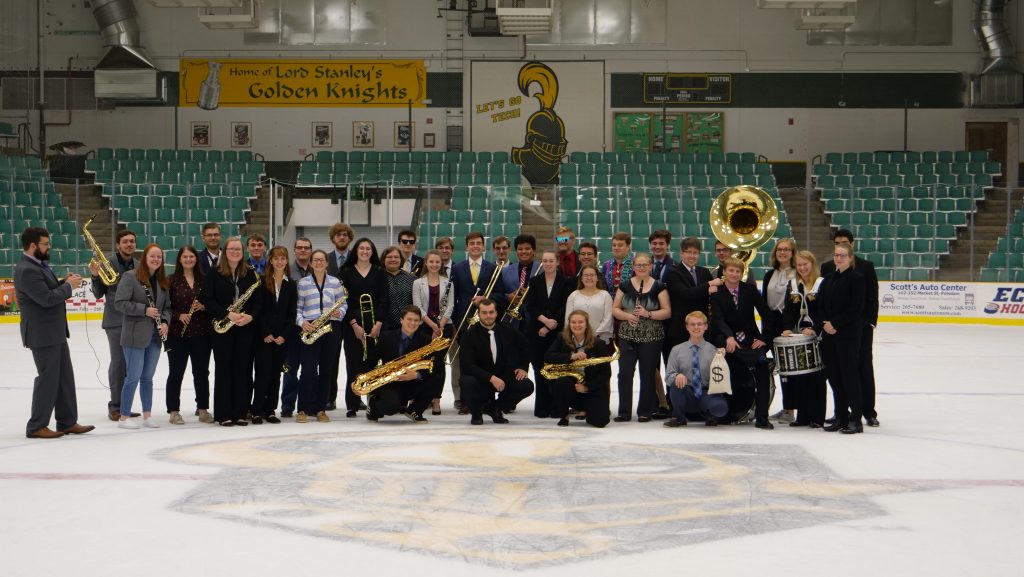 Students in Clarkson's Pep Band pose on the ice at Cheel Arena in their formal attire with their instruments during a Tony Tuesday event. 