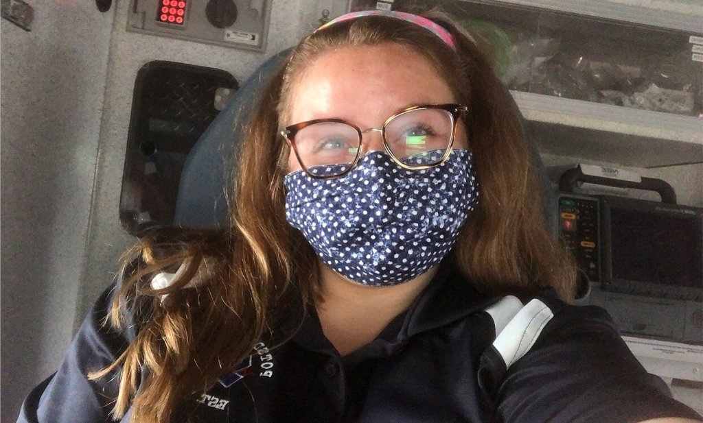 Megan wearing a mask sitting in the back of an ambulance while running calls for the Potsdam Rescue Squad