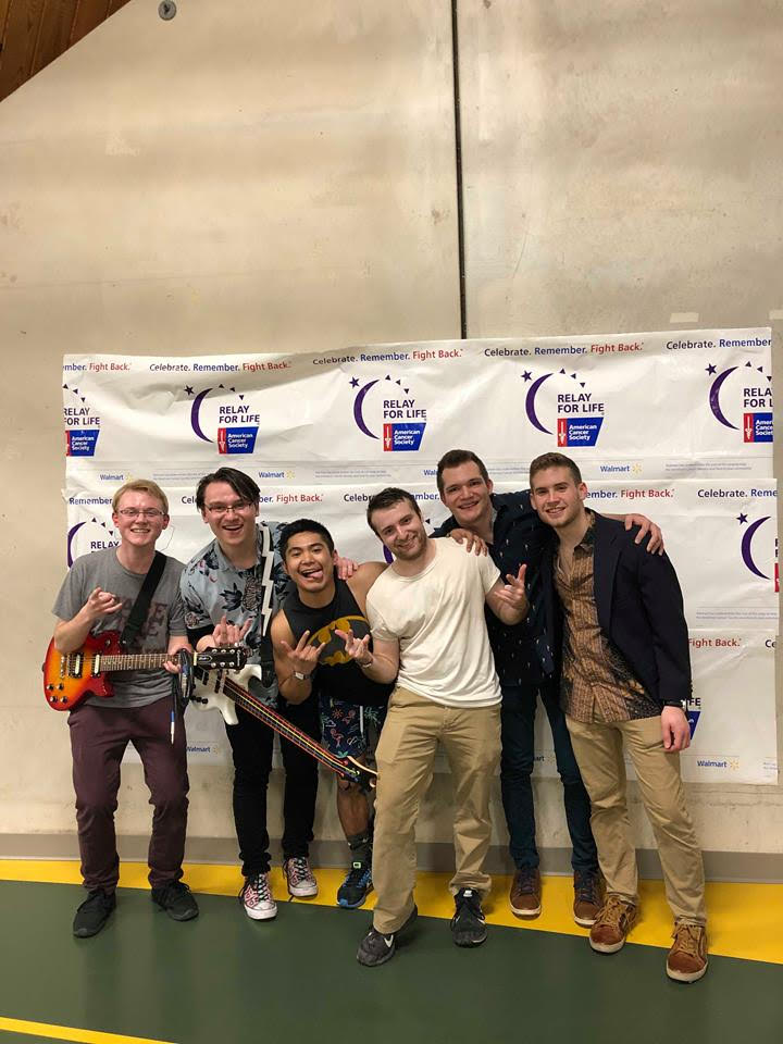 Wyatt and his bandmates, fellow Clarkson students posing in front of the Relay For Life banner.