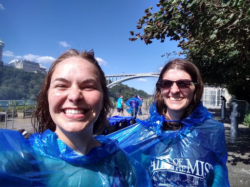 Jackie standing next to a friend wearing rain ponchos after leaving the maid of the mist in Niagara Falls