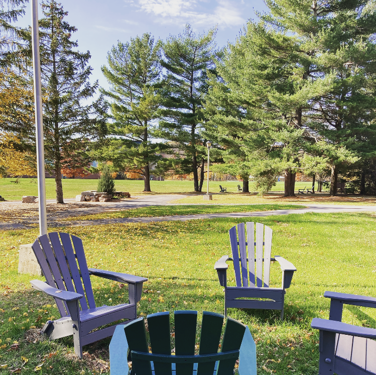 a sitting area with lawn chairs next to a footpath at Clarkson University