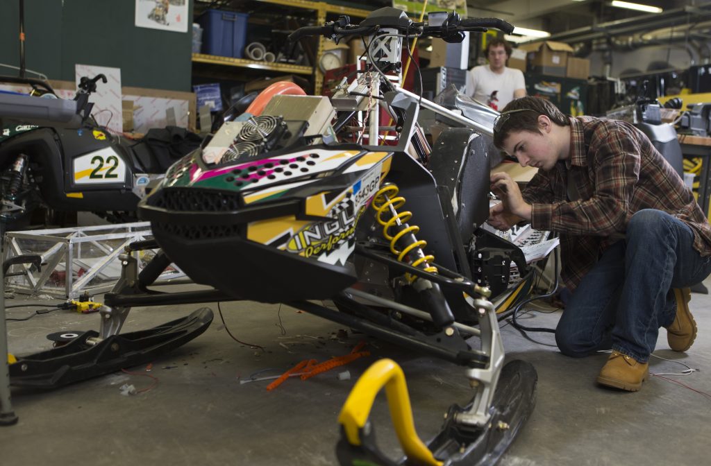 Students working on a snowmobile