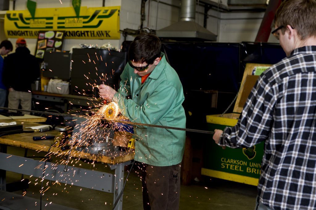 Students using tools and machines in the Clarkson University shop.