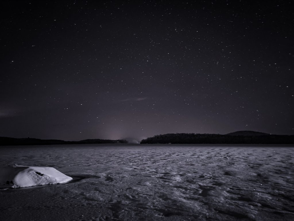 a barren frozen lake with a clear empty sky overhead