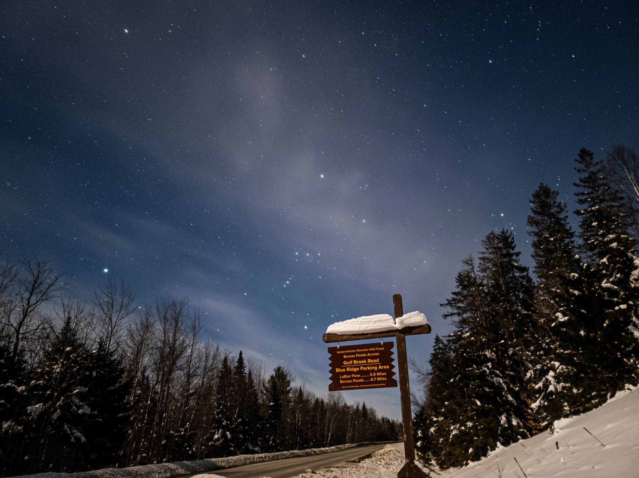 A starry night sky on a snowy Adirondack road