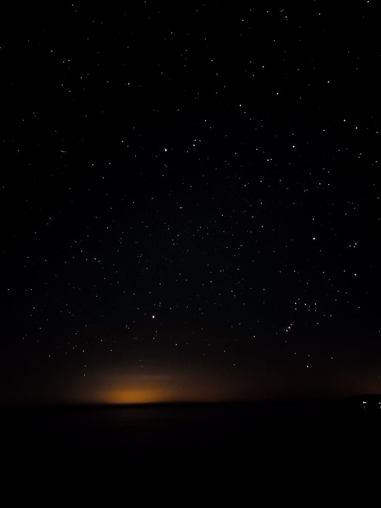 stars with a orange glow on the horizon