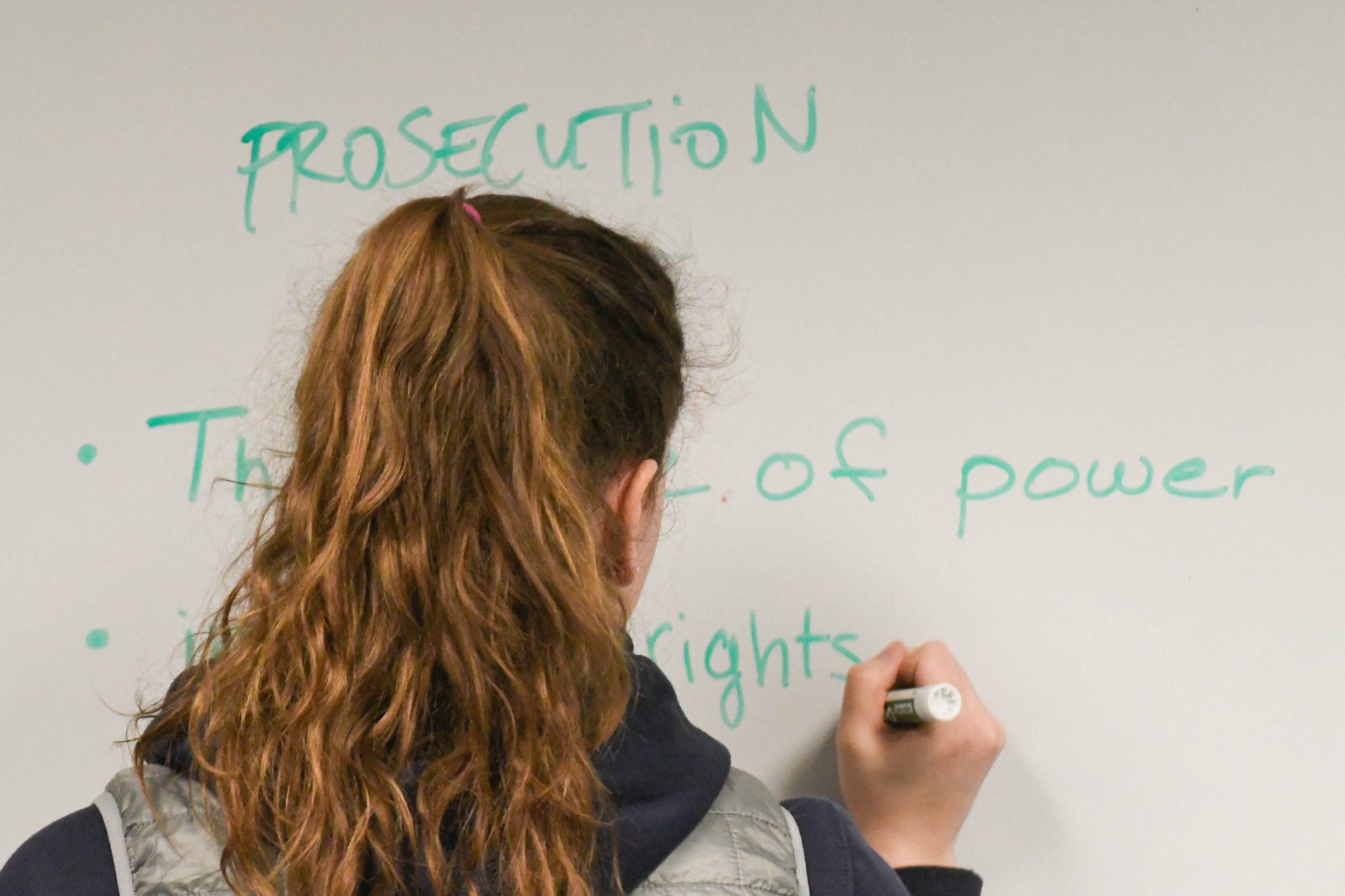 A student writing on a whiteboard.