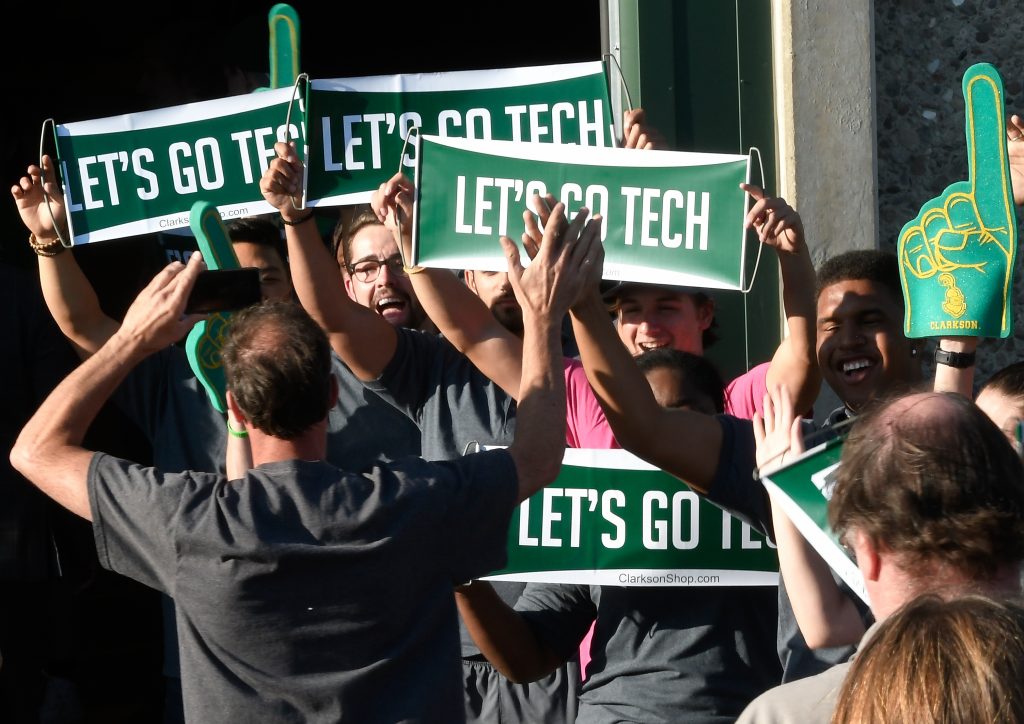 A group of students holding green 'Lets' Go Tech Banners' 
