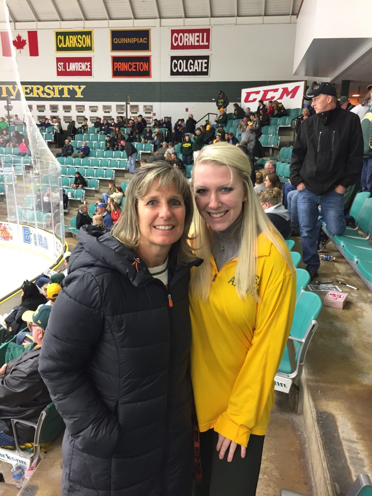Reagan and her mother at Cheel arena during a hockey games with fans in the background