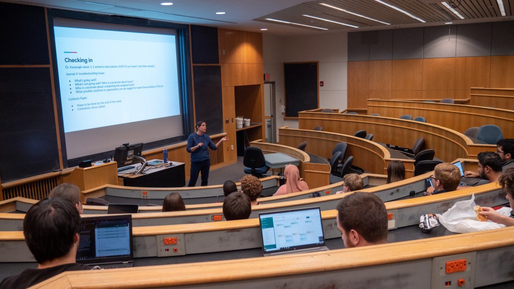 A lecture hall with students laptops on tables