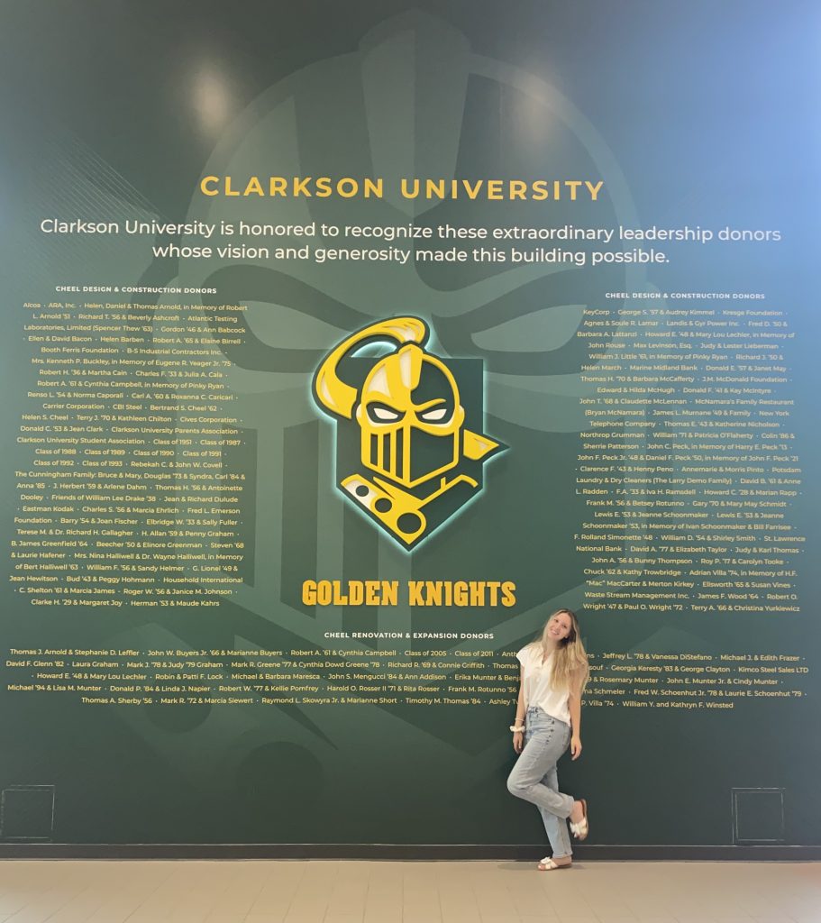 Jordan standing against the designed wall with the Golden Knight Logo on it