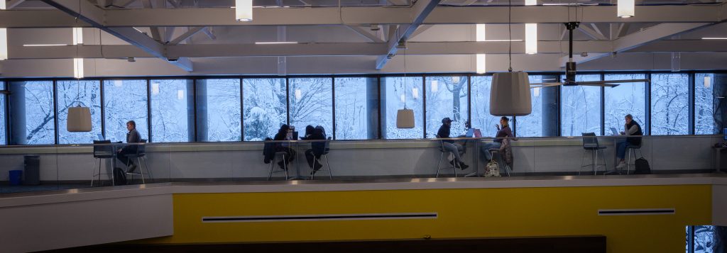 Students studying on the second floor of the ERC with a snowy campus behind them at Clarkson University