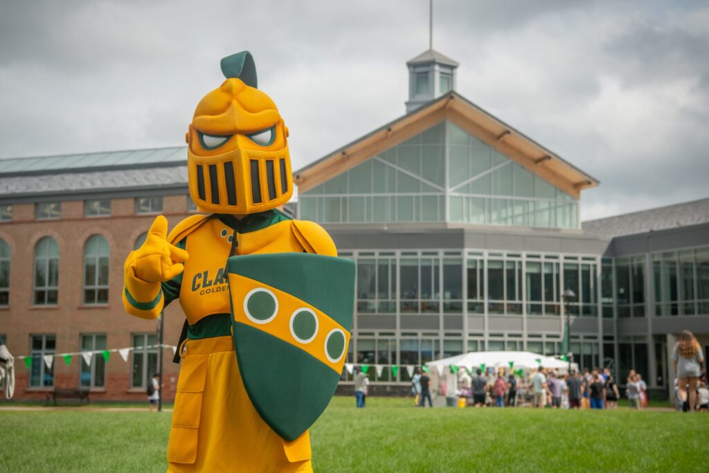 Clarkson University's mascot, the Golden Knight, posing in front of the Student Center at an event 