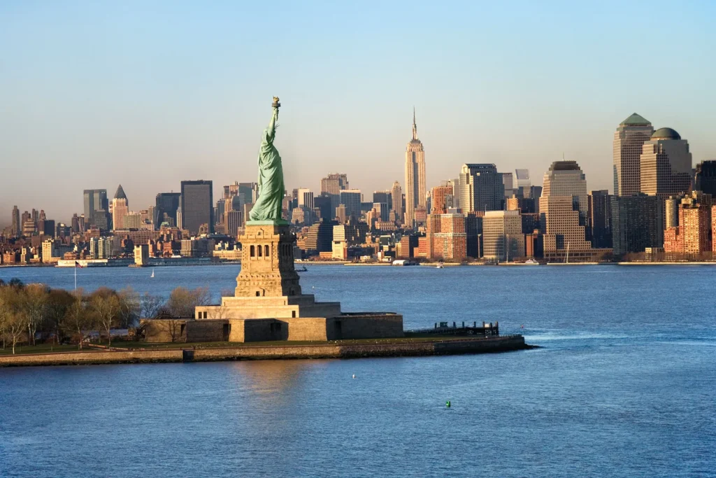 NYC skyline at daytime, with prominent view of the Statue of Liberty, lower Manhattan and the Upper Bay. JFK Airport in NYC is often the arrival point in the United States for international students.