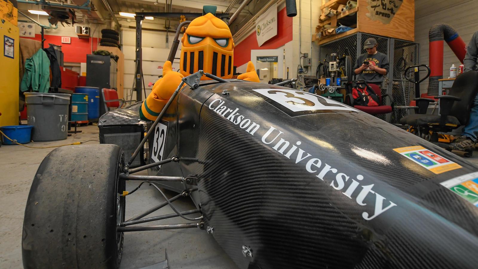 Clarkson University's mascot, the Golden Knight, sits in the driver seat of the Formula Electric Vehicle, made by engineering students