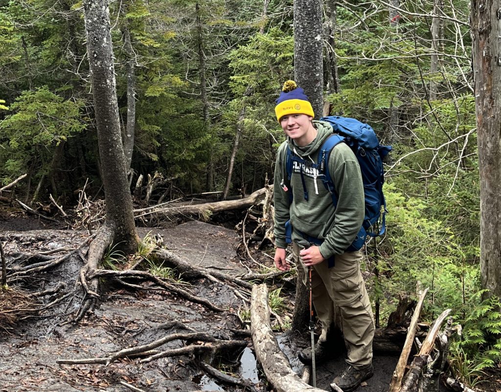 Clarkson University student studying Environmental Engineering, Jason Hofmann stands in a forest while hiking