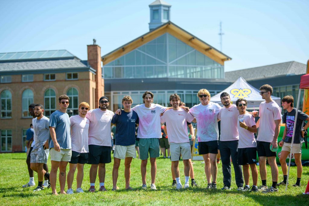 Group of students at Clarkson’s Welcome Carnival with campus buildings in the background.