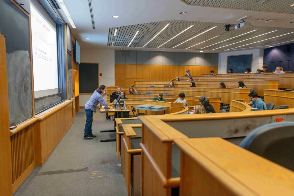Students attending a lecture in a tiered classroom at Clarkson University, part of the Business Administration program experience.