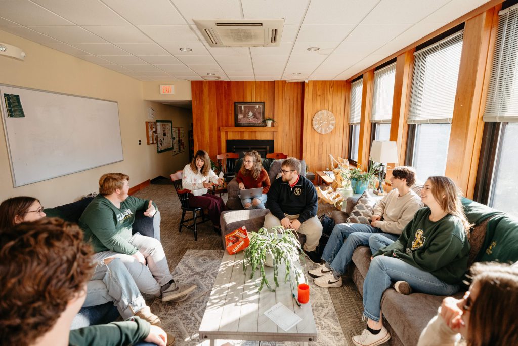 A group of students and staff at Clarkson University sit and talk.