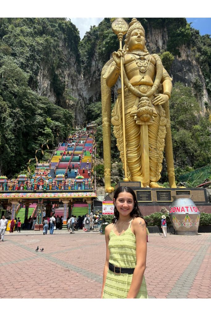 A Clarkson University E&M student poses in front of a statue in Singapore.