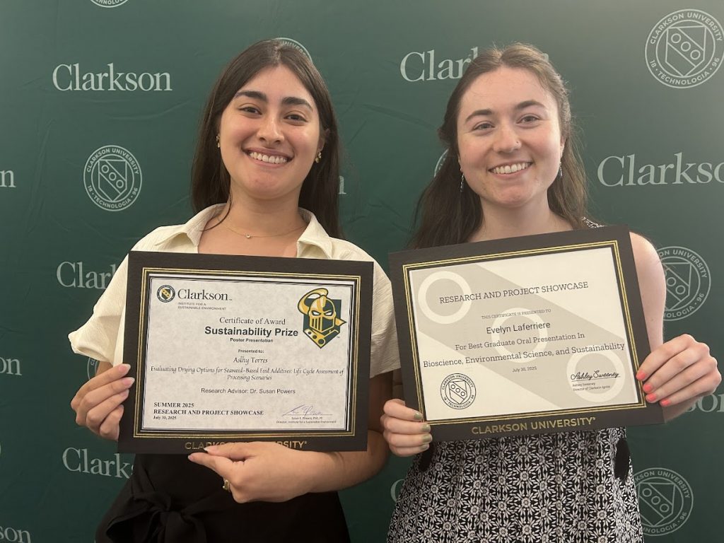 Two Clarkson University students hold award certificates related to their work in sustainability