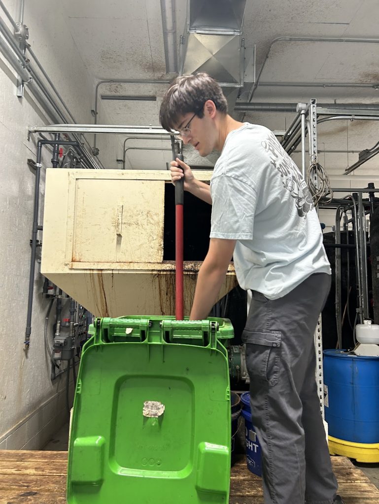 Jonas putting food waste into the digester