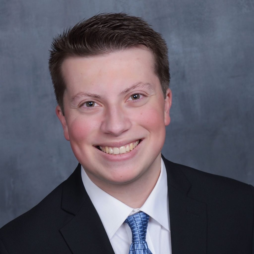 A headshot of Miles Compani, wearing formal attire.
