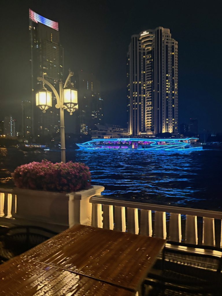 A cruise ship lit up on the water. 