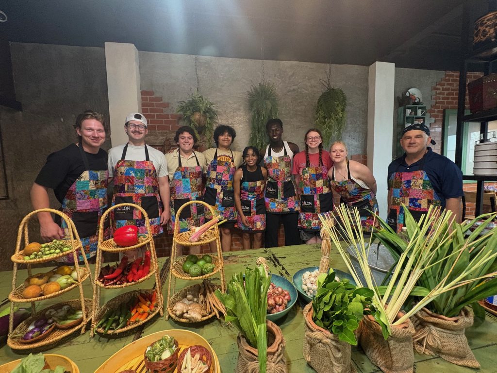 A picture of students and a professor at a cooking class.